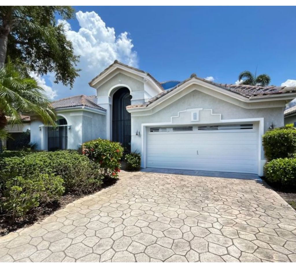 Charming Light Gray Exterior: Rustic Roof & Black Arched Doors