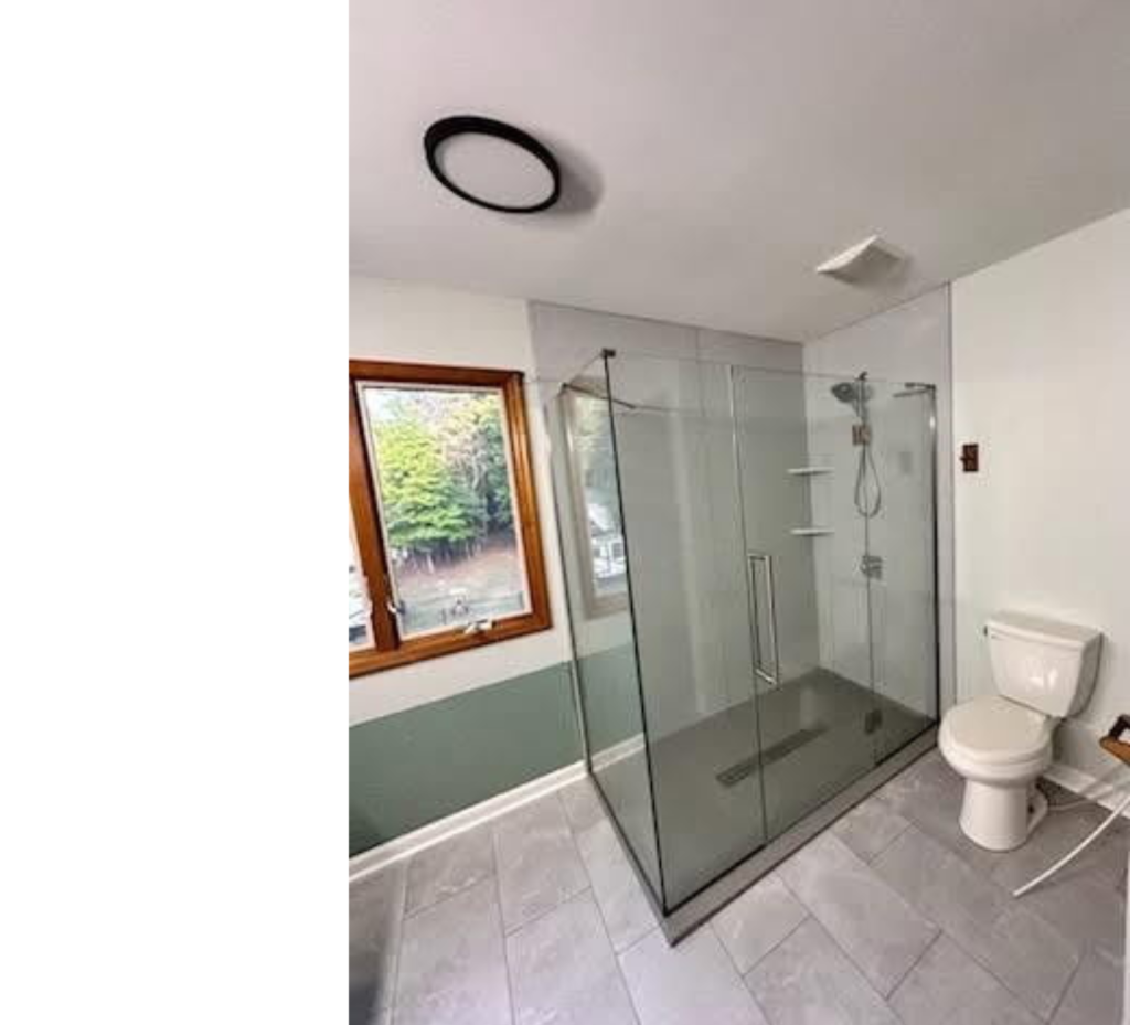 Sleek & Airy Bathroom Remodel with Light Gray Tiles, Glass Shower & Wood Window Accent