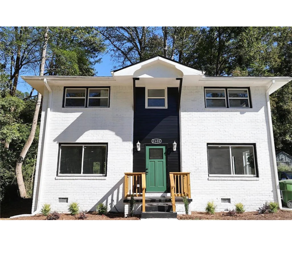 Modern Charm: White Brick Exterior with Bold Black Center & a Pop of Green on the Front Door