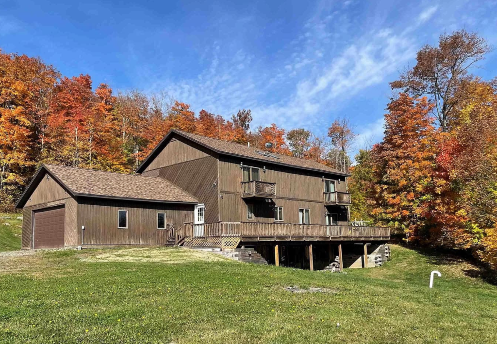 Autumnal Retreat: A Wood-Clad Home Embraced by Vibrant Fall Foliage