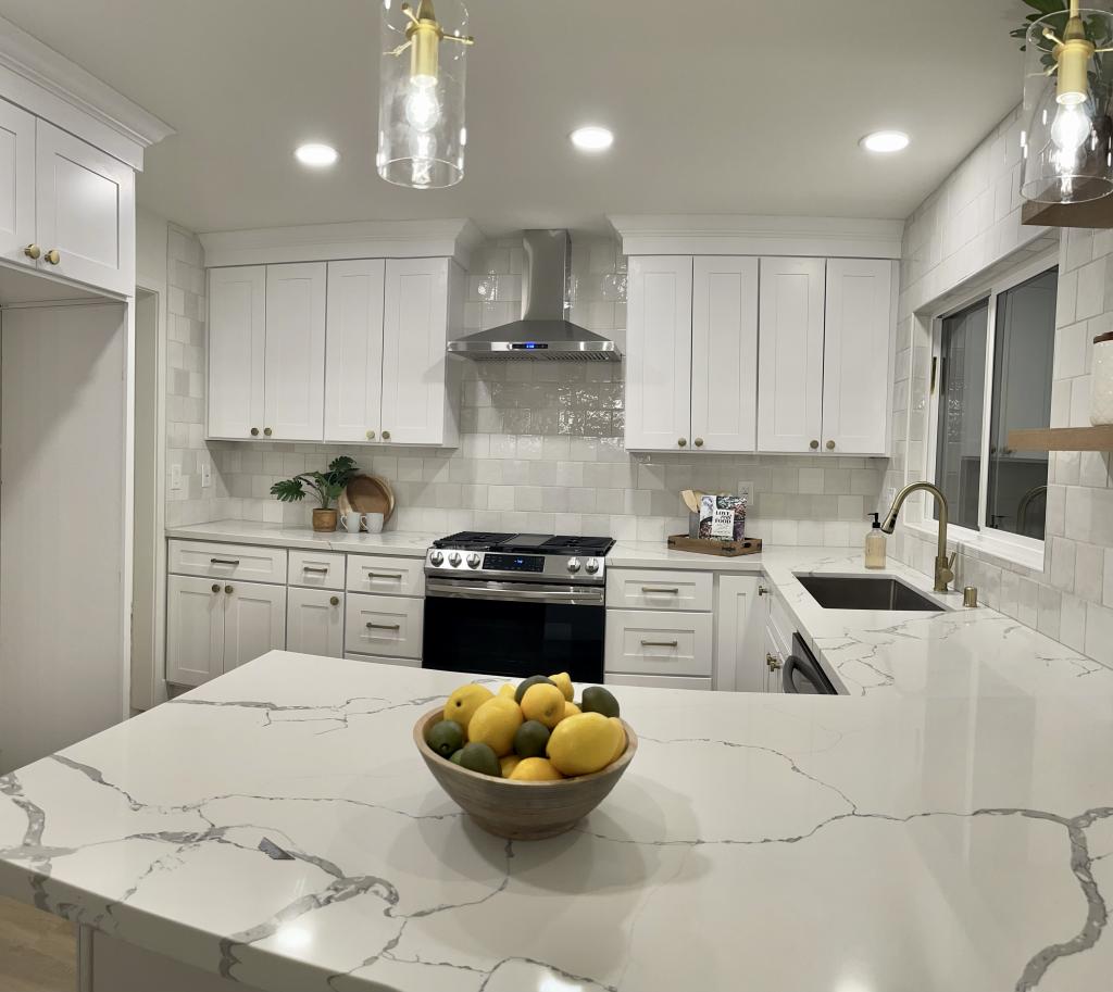 Effortless Elegance: White Kitchen Remodel with Marble Countertops & Bold Black Appliances