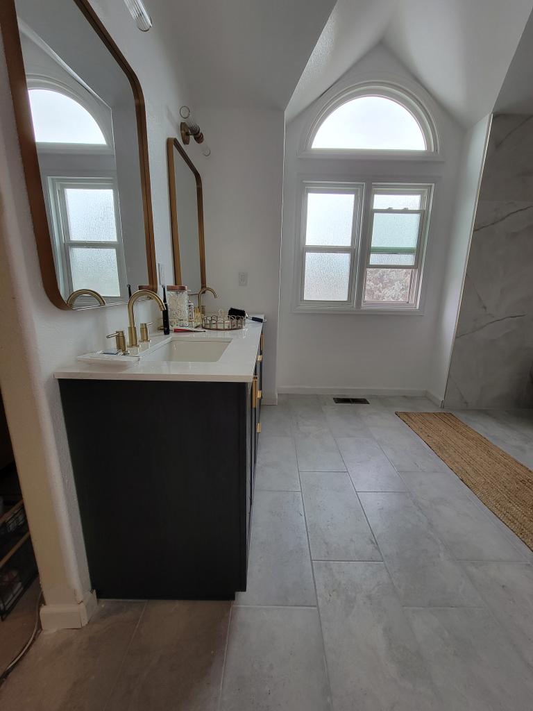 Timeless Charm: White Bathroom Remodel with Wood Accents and Arc Window