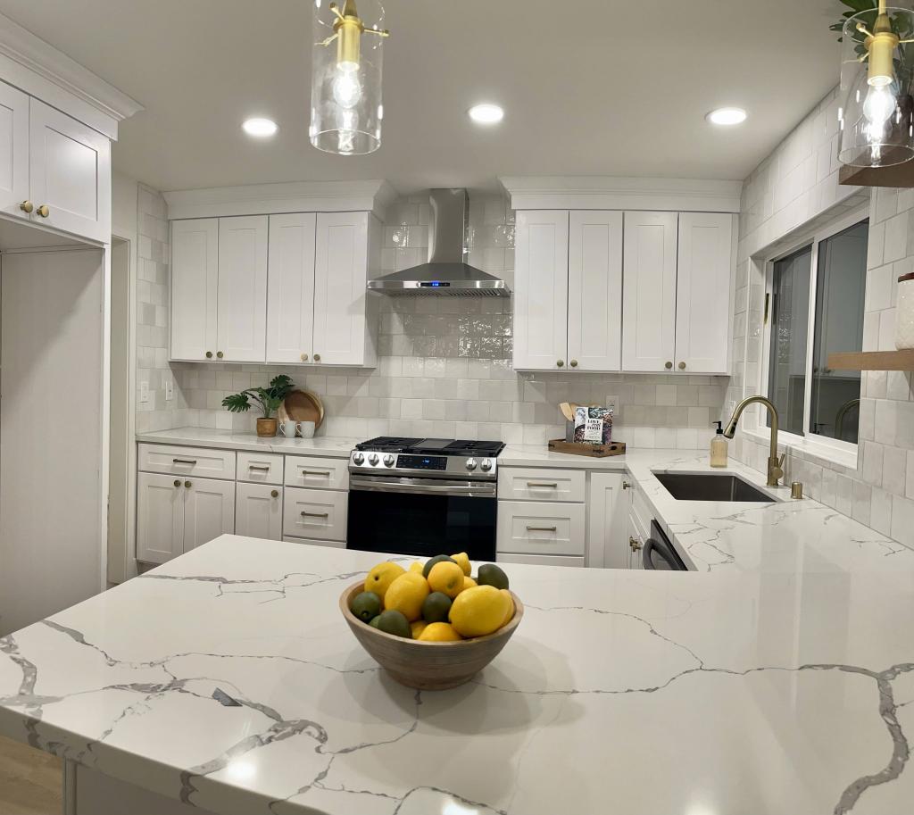 Effortless Elegance: White Kitchen Remodel with Marble Countertops & Bold Black Appliances